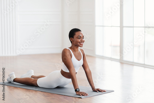 Young black woman stretching back on mat in cobra pose