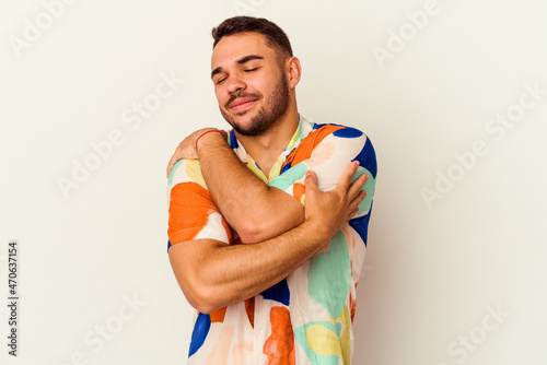Young caucasian man isolated on white background hugs, smiling carefree and happy.
