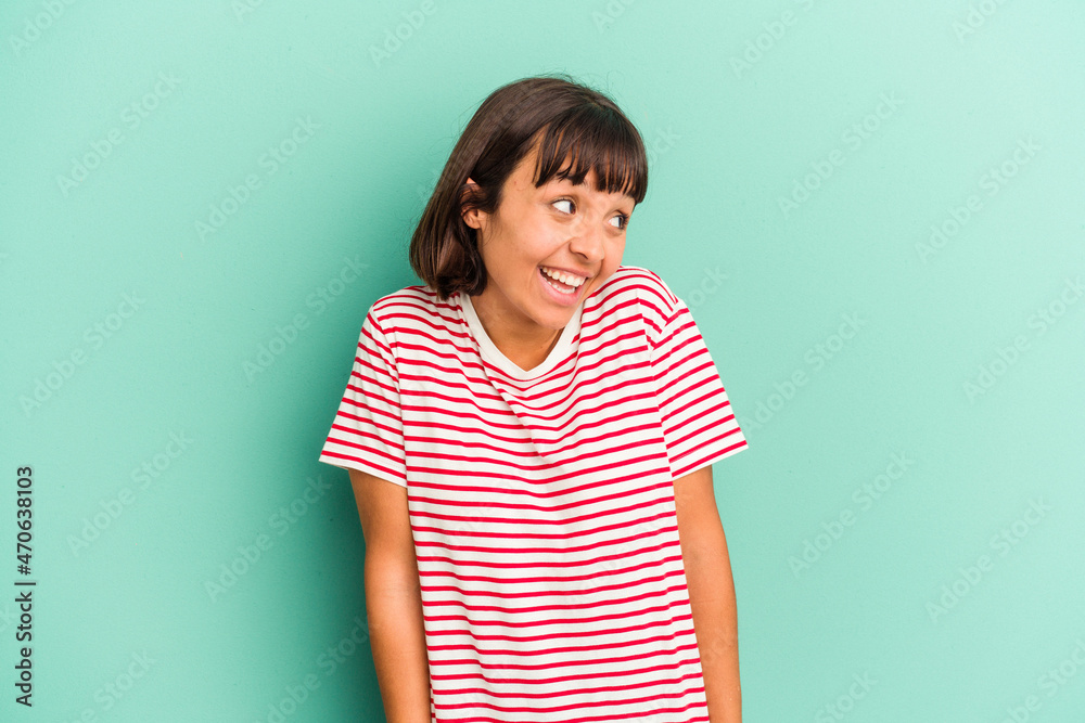 Young mixed race woman isolated on blue laughs and closes eyes, feels relaxed and happy. Young mixed race woman isolated on blue laughs and closes eyes, feels relaxed and happy.