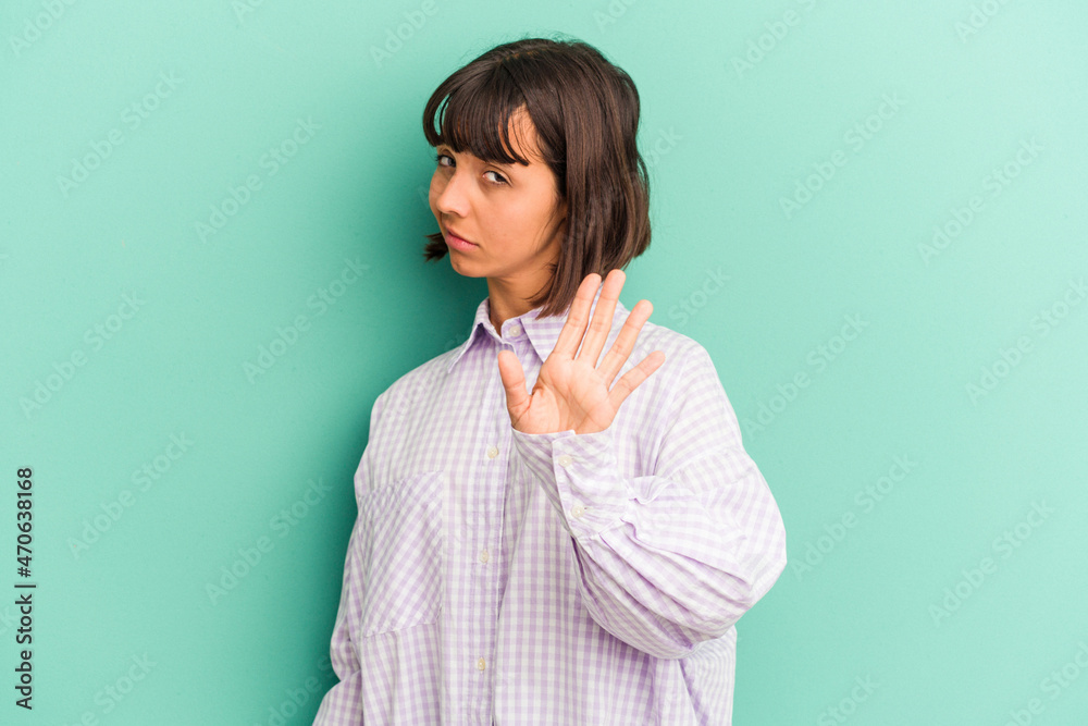 Fototapeta premium Young mixed race woman isolated on blue rejecting someone showing a gesture of disgust.