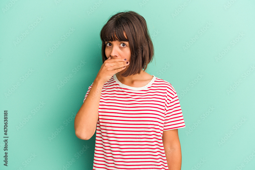 Young mixed race woman isolated on blue covering mouth with hands looking worried. Young mixed race woman isolated on blue covering mouth with hands looking worried.
