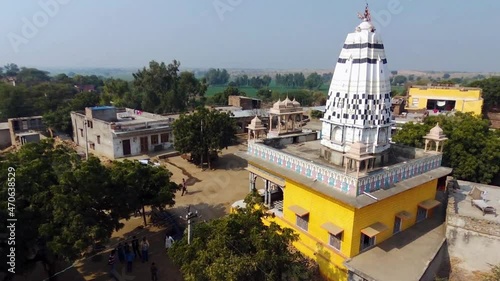 Aerial pedestal up and panning of colorful Hindu temple of rural Indian village of Khera Kiran in Rajasthan, India photo