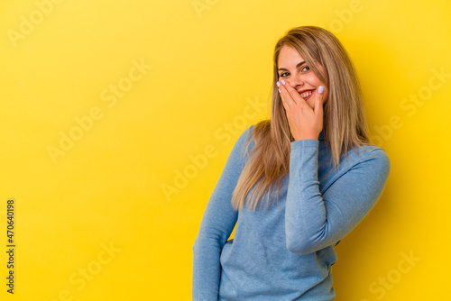 Young russian woman isolated on yellow background laughing happy, carefree, natural emotion.