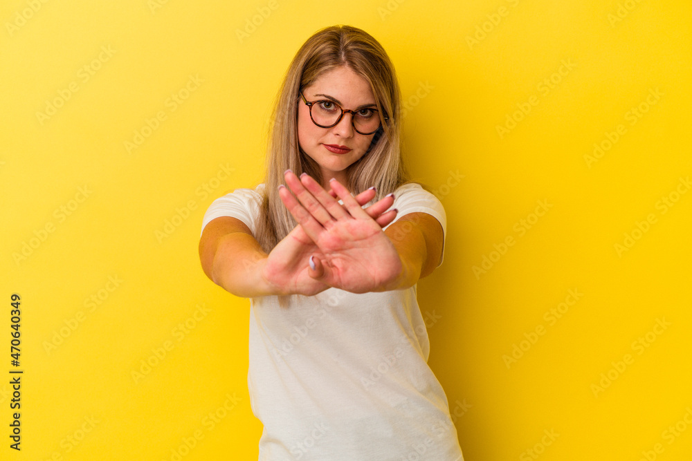 Young russian woman isolated on yellow background doing a denial gesture Young russian woman isolated on yellow background doing a denial gesture