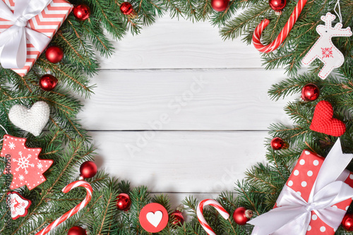 A model of a frame made of fir branches with Christmas decorations, sweets and gifts.