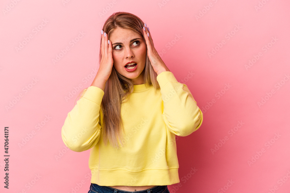 Young russian woman isolated on pink background covering ears with hands trying not to hear too loud sound. Young russian woman isolated on pink background covering ears with hands trying not to hear too loud sound.