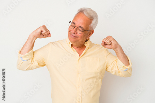 Senior american man isolated on white background stretching arms, relaxed position. © Asier