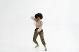 Serious black woman dancing on white background