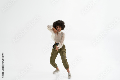 Serious black woman dancing on white background