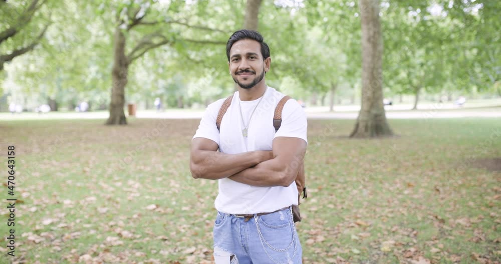 Portrait of confident man crossing arms in public park Portrait of confident man crossing arms in public park