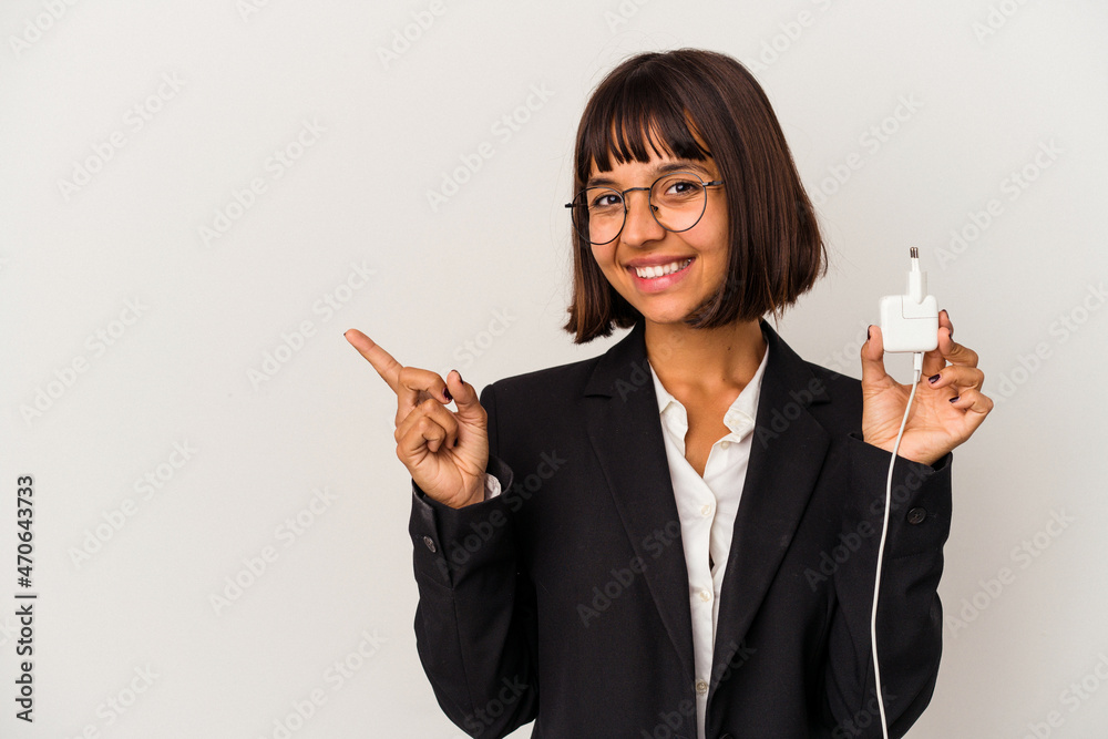 Young mixed race business woman holding a phone charger isolated on white background looks aside smiling, cheerful and pleasant. Young mixed race business woman holding a phone charger isolated on white background looks aside smiling, cheerful and pleasant.