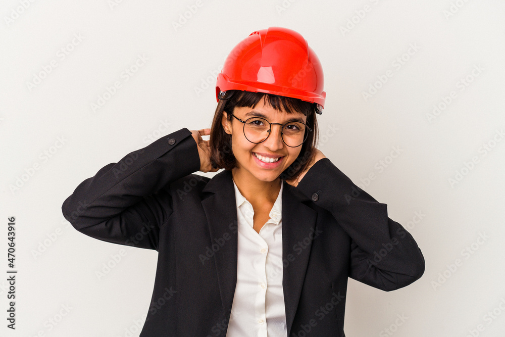 Young architect woman with red helmet isolated on white background stretching arms, relaxed position. Young architect woman with red helmet isolated on white background stretching arms, relaxed position.