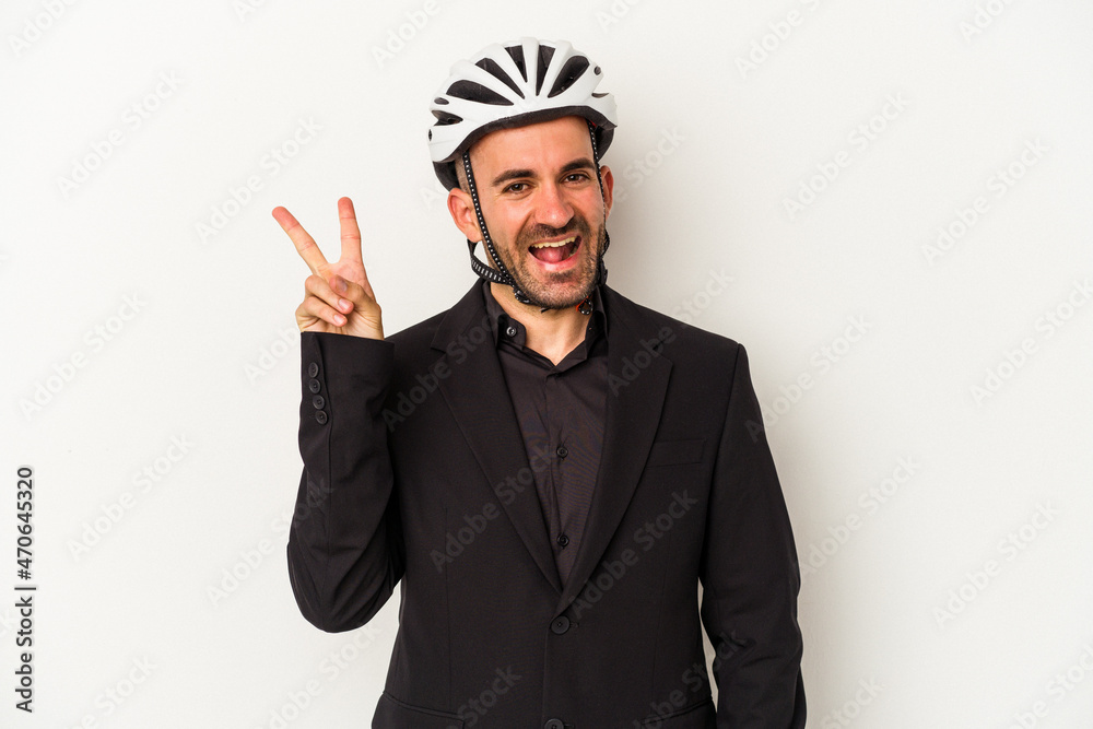 Young business bald man wearing a bike helmet isolated on white background  joyful and carefree showing a peace symbol with fingers.