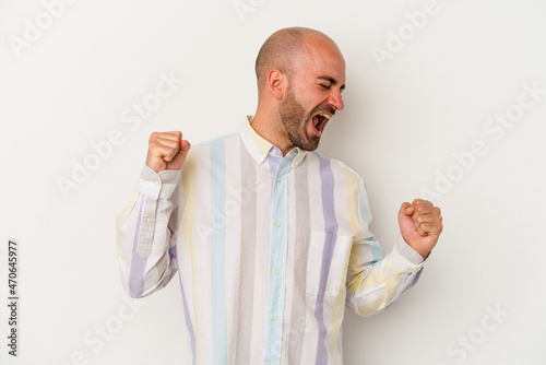 Young bald man isolated on white background dancing and having fun.