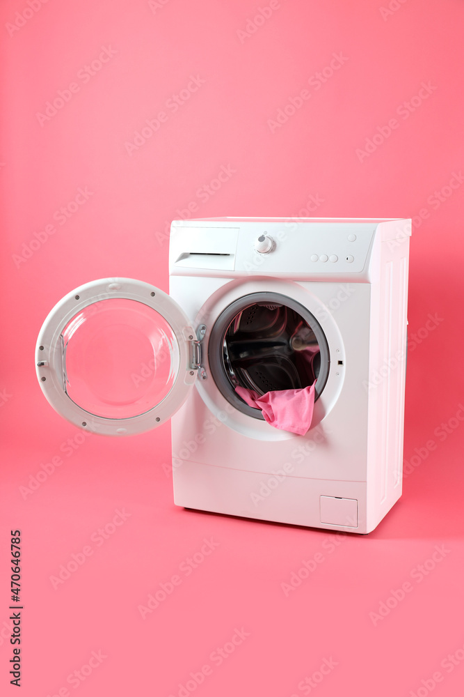 Concept of housework with washing machine on pink background