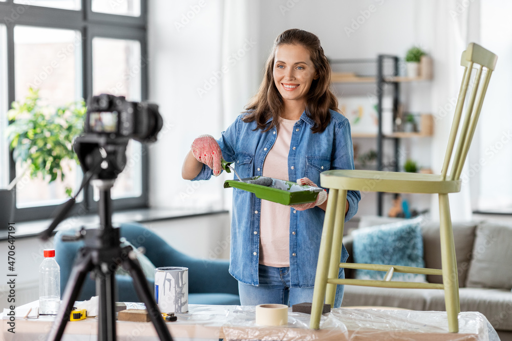 blogging, furniture restoration and home improvement concept - happy smiling woman or blogger with paint roller and tray recording tutorial video about old wooden chair renovation with camera blogging, furniture restoration and home improvement concept - happy smiling woman or blogger with paint roller and tray recording tutorial video about old wooden chair renovation with camera