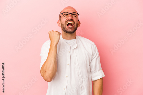 Young caucasian bald man isolated on pink background celebrating a victory, passion and enthusiasm, happy expression.