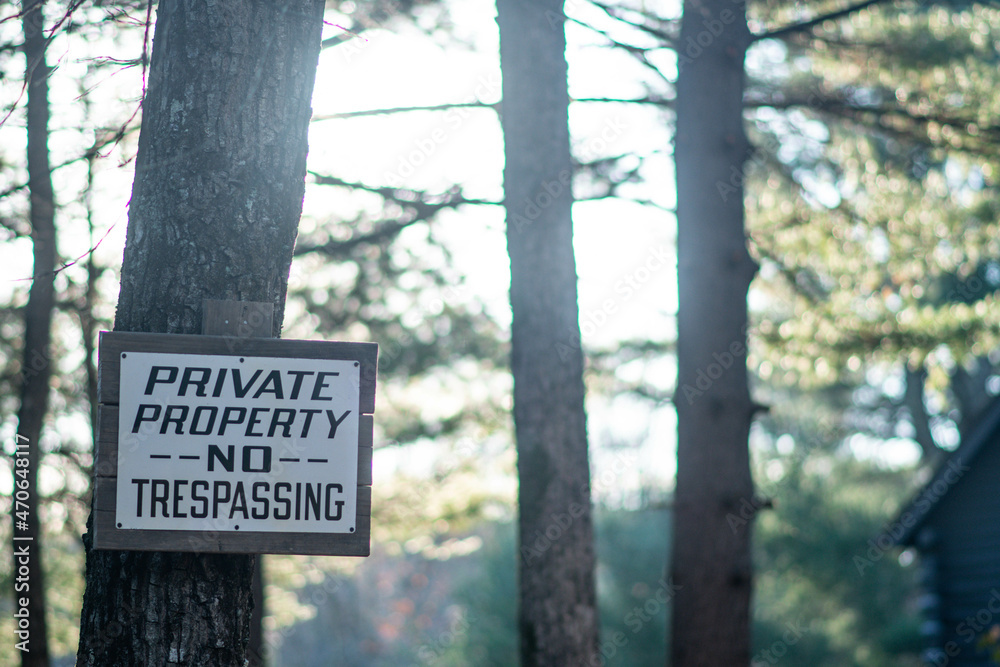 Private property sign in a woods outdoor environment, farm house in nature.