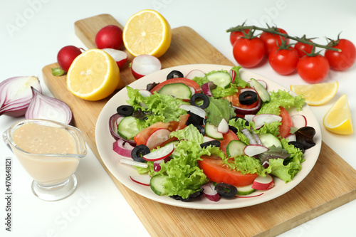 Concept of tasty food with vegetable salad with tahini sauce on white background