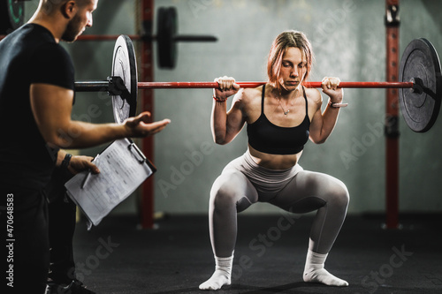 Woman Exercising With Personal Trainer At The Gym