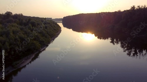 Beautiful flight over river  with reflection of red sun. Aerial landscape