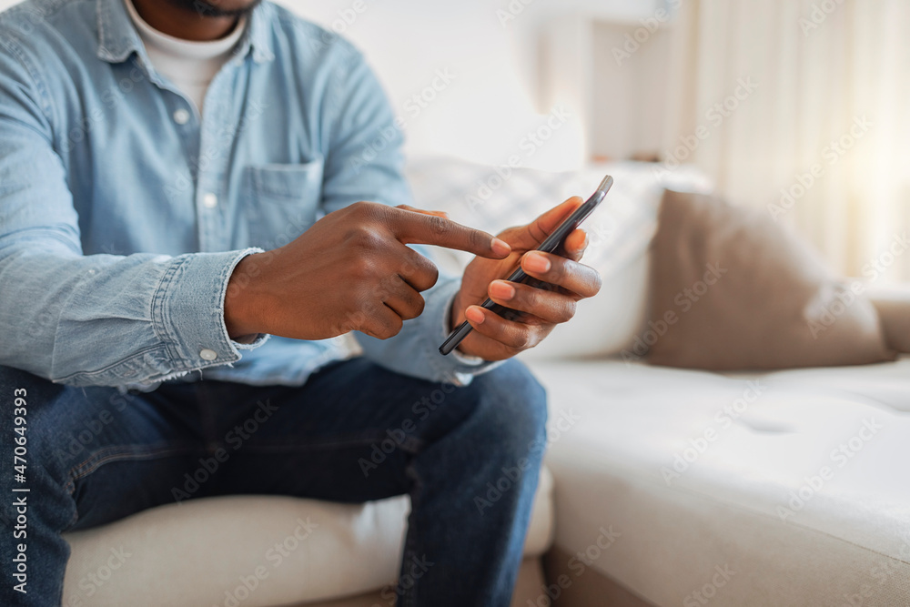 Young men using mobile phone. Close up of a man hand holding cellphone with internet browser on screen. Business, communication, technology concept. African guy working from home with cell phone.