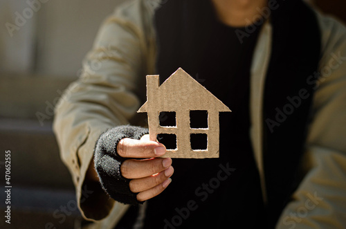 A homeless man who is discouraged, desperate, erring from life. homeless A homeless beggar handed a picture of a paper house for help with donations.