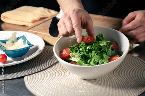 
Control para subir videos
Control para subir videos
100%
10
G24

Hands of a cook placing a halved cherry tomato on top of a green salad served in a bowl.
