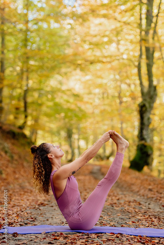 Latin woman practicing yoga in the forest. photo