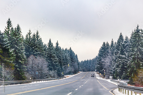 Road street between snowed in trees winter landscape Harz Germany