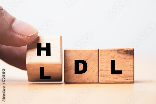 Hand flipping wooden cube block from change LDL to HDL for High is high density lipoprotein and LDL is low density lipoprotein concept. photo