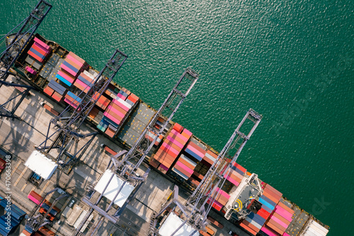 containers Commercial shipping port and container ship loading unloading by crane global business and industry services import export transportation international worldwide in sea aerial view