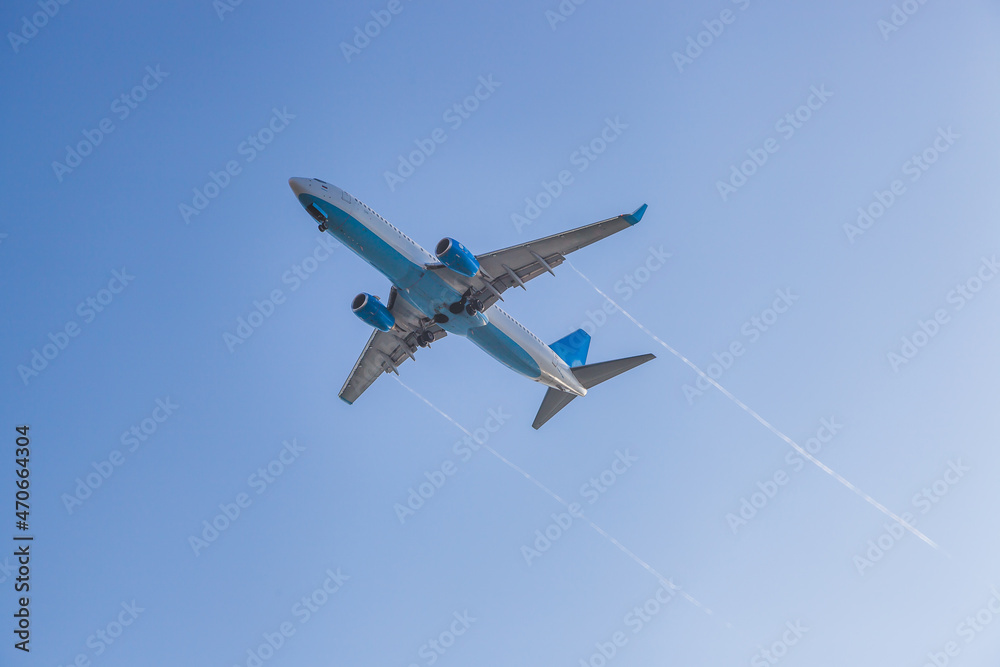 the plane flies against the background of the blue sky the plane flies against the background of the blue sky