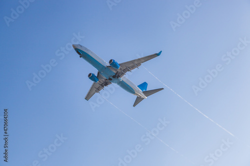 the plane flies against the background of the blue sky
