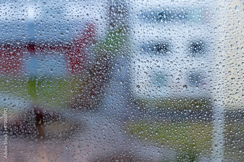 Raindrops on glass on a blurred background. Rain on the window. Dripping rain on the window. Photo