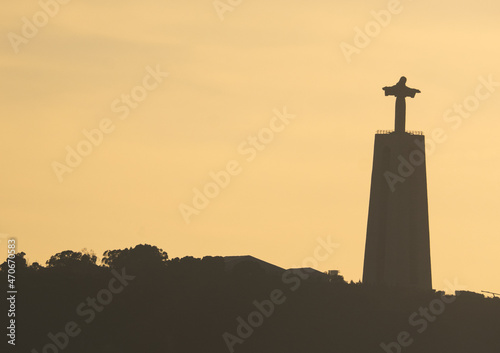 Lisbon at sunset, silhouette of the statue of Christ the King. Portugal