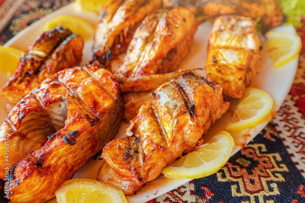 Grilled whitefish with lemon slices. Armenian cuisine and fish of Sevan lake concept Grilled whitefish with lemon slices. Armenian cuisine and fish of Sevan lake concept