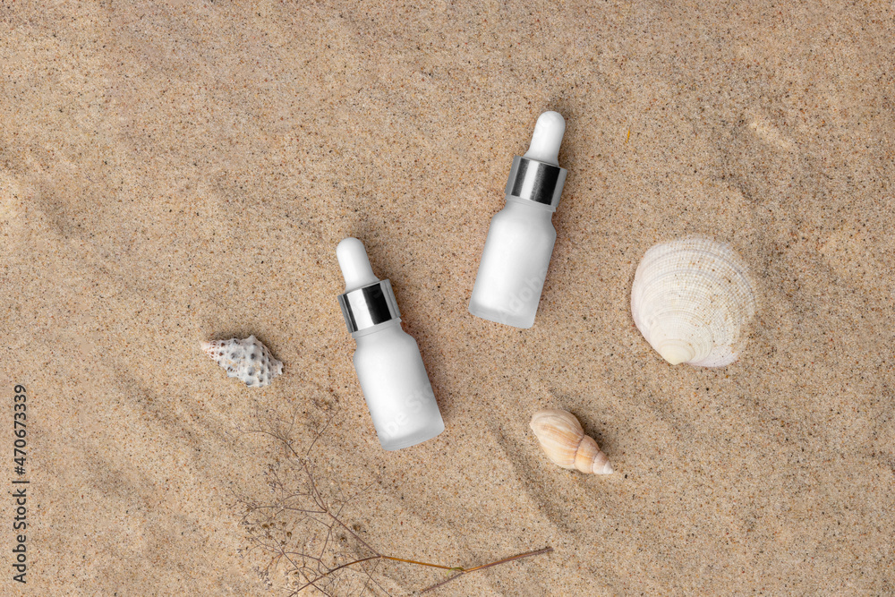 Cosmetics branding mockup template, real photo, dropper, tube, bottle blank isolated on a sea sand background with shells to place your design. Cosmetics branding mockup template, real photo, dropper, tube, bottle blank isolated on a sea sand background with shells to place your design.