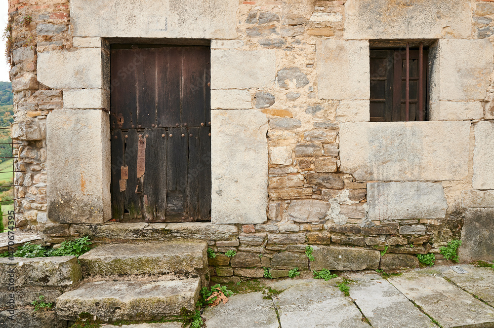 Stone wall with old entrance and wooden door