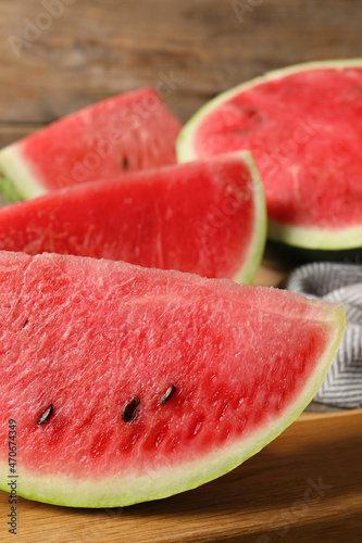 Delicious fresh watermelon slices on wooden board, closeup