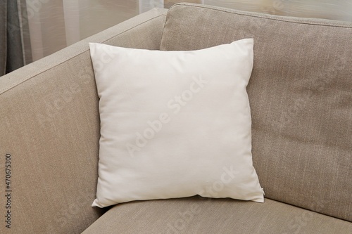 White square canvas pillow mockup on cozy couch,  small cotton cushion mockup in living room interior., space for design presentation. photo