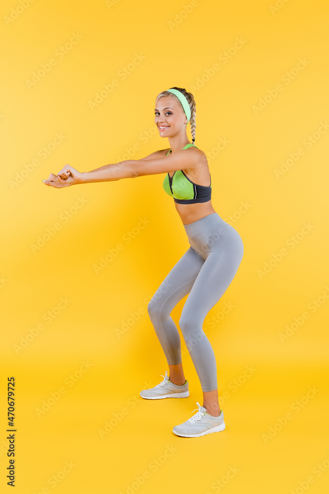 full length view of young and sportive woman doing sit ups on yellow full length view of young and sportive woman doing sit ups on yellow