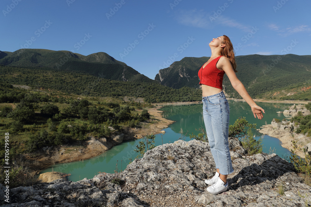 Fototapeta premium Woman relaxing breathing fresh air in a lake