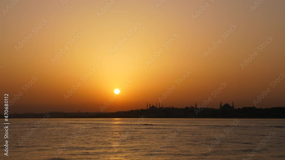 Time lapse shot of summer sunset in Istanbul, Bosphorus estuary and Fatih view. Sun move down and disappear in sky, become dark. Small boats and passenger ferry sail forth and back on water Time lapse shot of summer sunset in Istanbul, Bosphorus estuary and Fatih view. Sun move down and disappear in sky, become dark. Small boats and passenger ferry sail forth and back on water