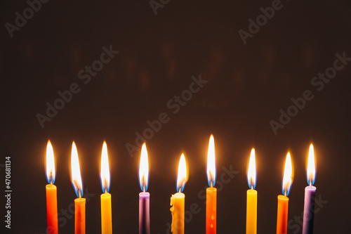 Jewish Holiday Hanukkah background with candles and traditional candelabra menorah on dark background. Jew festival of lights concept.