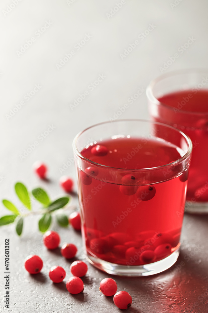 Fresh cranberry drink in a glass and berries on the table. Tonic medicinal drink. Fresh cranberry drink in a glass and berries on the table. Tonic medicinal drink.