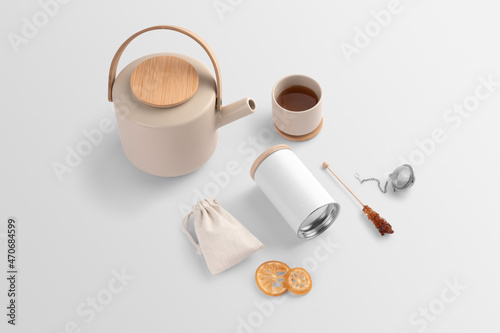 Blank tea packaging container, pot, teacup, bag, dried fruits, sugar stick, on a white background, packaging mockup with empty space to display your branding design.
