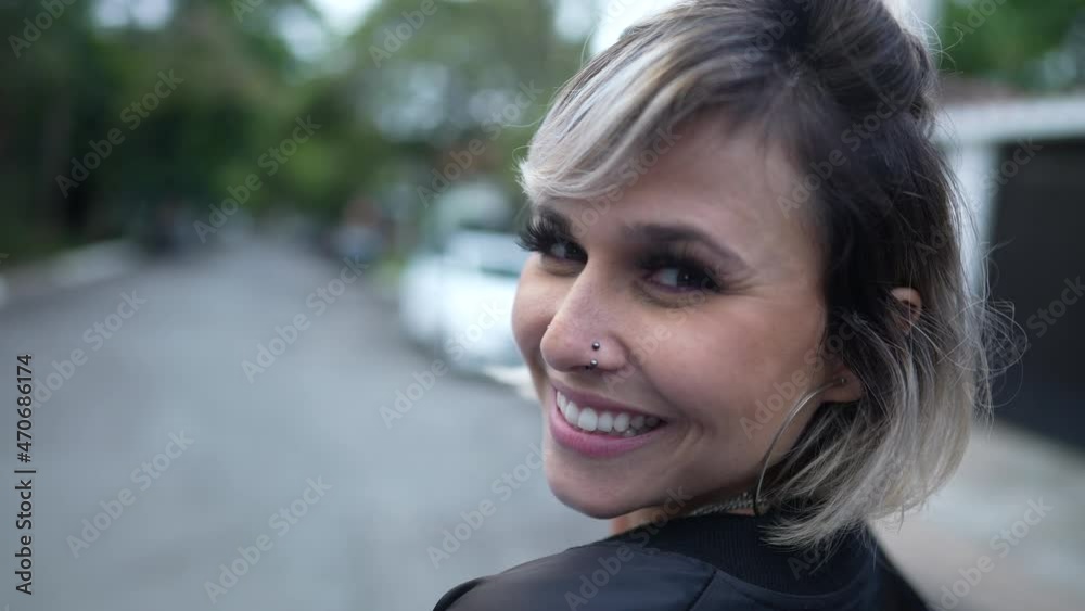 Happy woman turning head toward camera smiling Happy woman turning head toward camera smiling