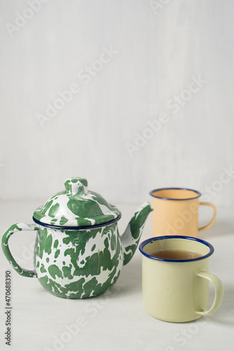 Stripes vitreous enamel teapot and glass isolated on white background