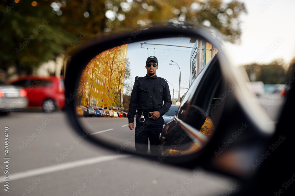 Police officer, view through car rear view mirror - obrazy, fototapety, plakaty 